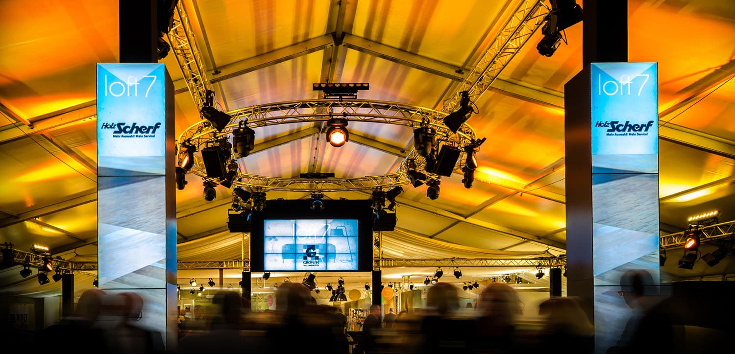 Messestand mit AV-Technik und Besucherverkehr.