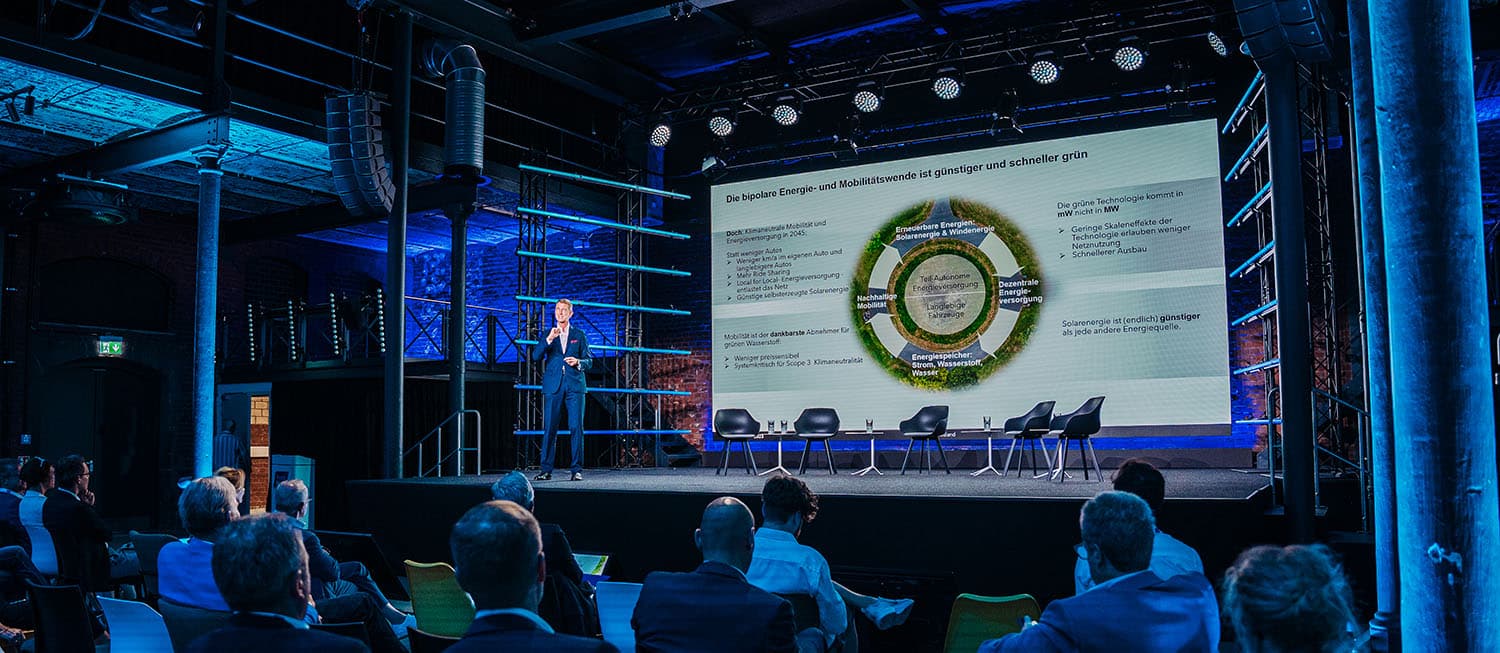Konferenz aus Sicht des Publikums mit Blick auf die Bühne.